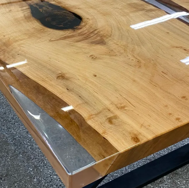 Close-up of live edge wood table with clear resin edges and high-gloss finish.