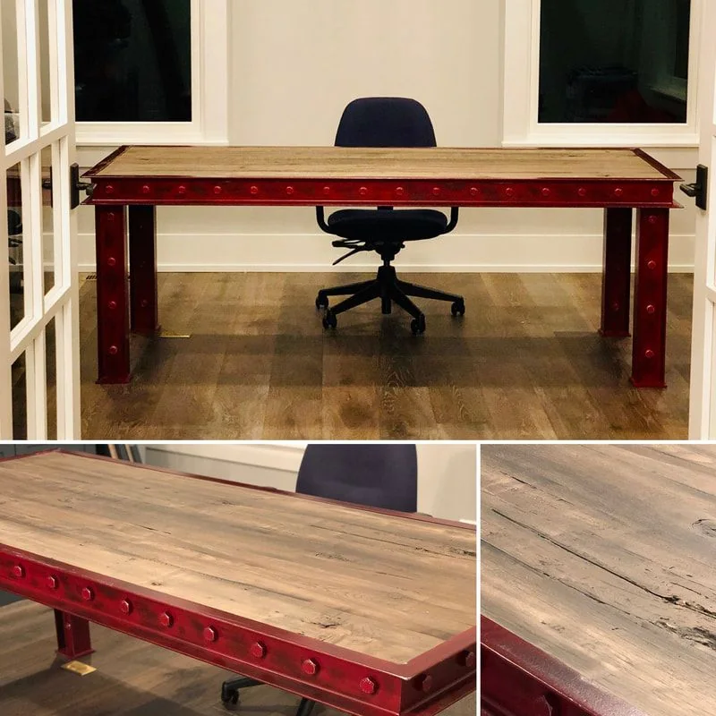 A large rectangular wooden desk with a rustic finish and red metal legs featuring circular rivet details. An office chair sits behind the desk in a room with wooden flooring, white walls, and two windows. The image also includes close-up views of the desk’s wood grain and metalwork, emphasizing its industrial and rustic design elements.