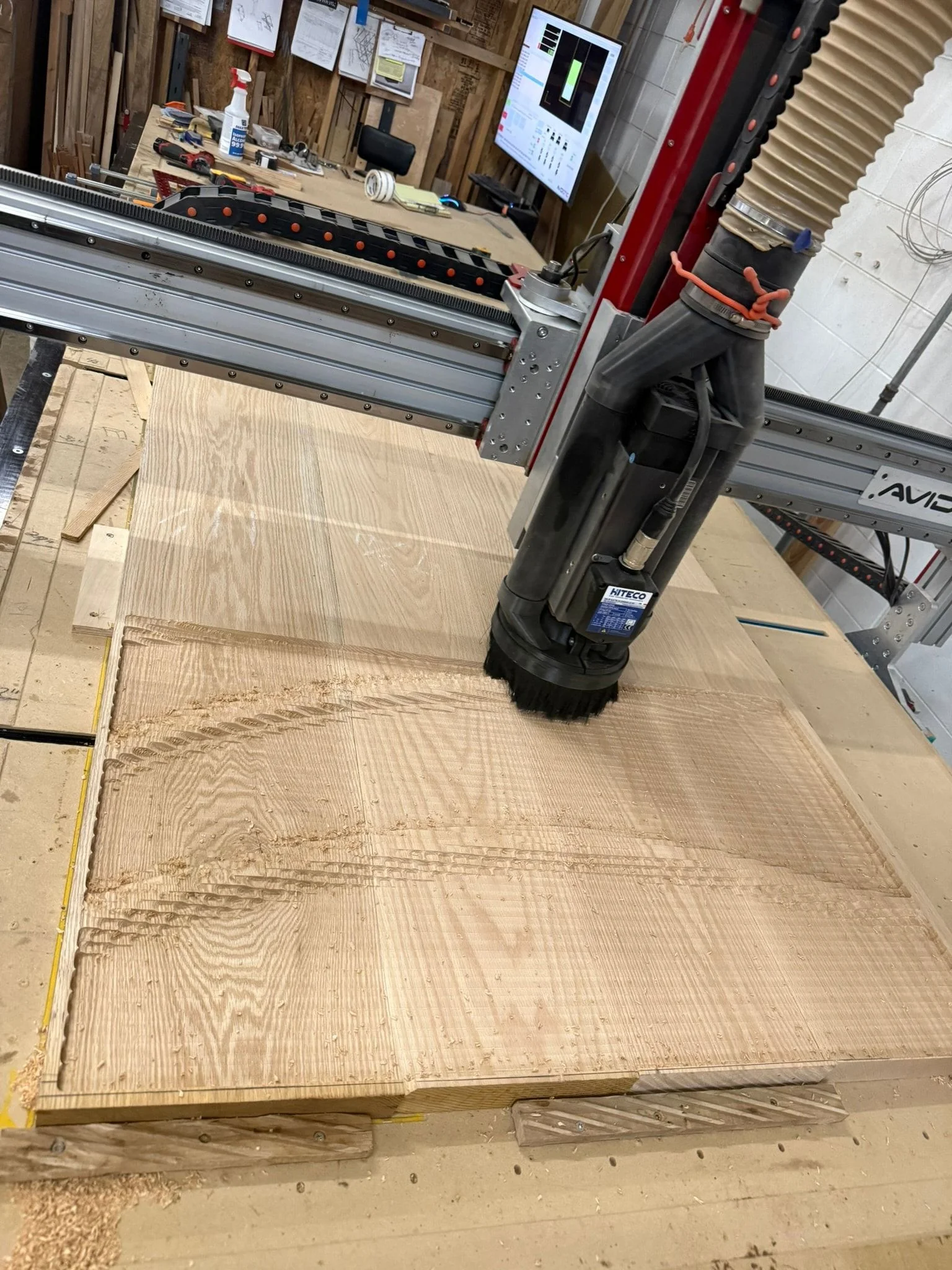 A router head making its first passes across a glued-up wood panel.