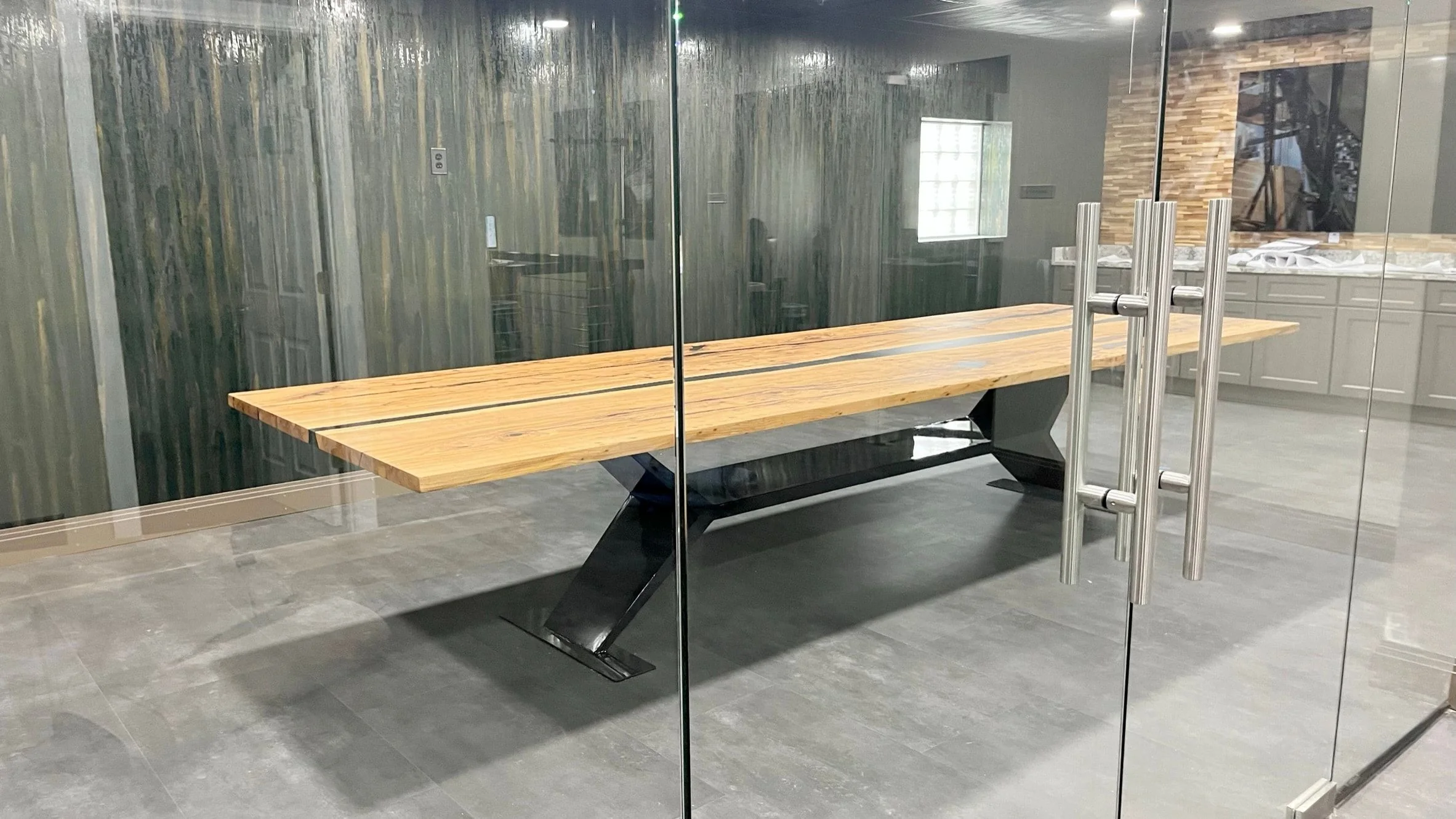 The same conference table seen through the glass wall and doors of the room.