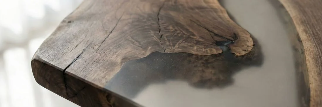 Close-up of an epoxy resin dining table showing natural wood grain and clear epoxy detail