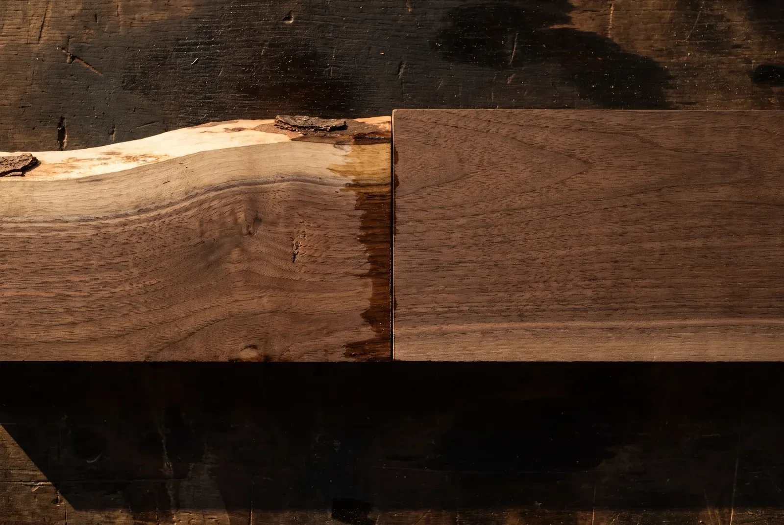 Two hardwood offcuts butted together: one with an undulating natural live edge, one with a dead-straight machined edge.