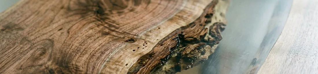 Close-up of wood and epoxy dining table showing grain structure and epoxy transition